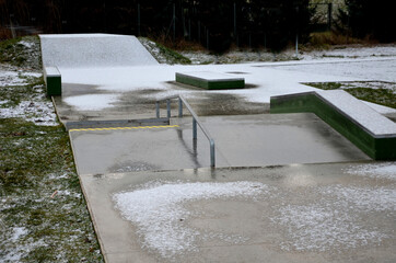 Skateboard park with concrete cement surface with concrete skateboard obstacles is designed for...