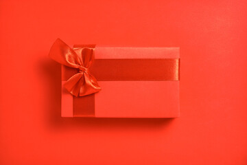 Bright red rectangular gift box on a red paper background. Top view. A passionate gift.