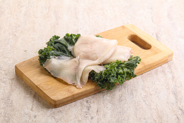 Raw squid over wooden board