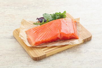 Raw salmon fillet over board
