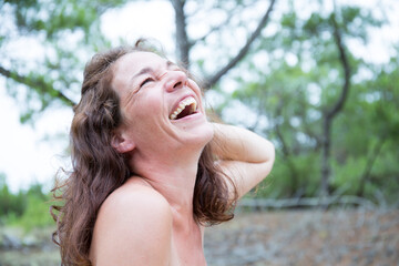 Topless woman smiling laughing happy in park forest
