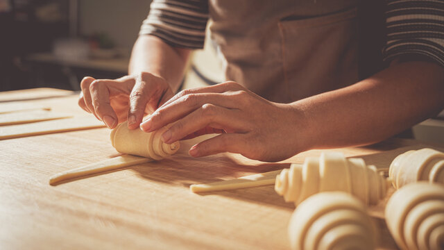 Young pastry chef making some croissant in the bakery.food concept and bakery background.