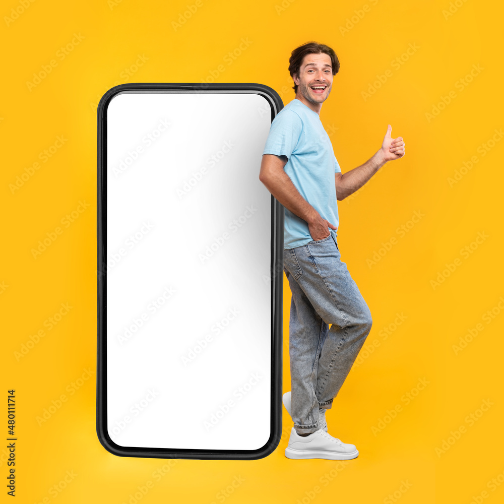 Poster man showing white empty smartphone screen and ok sign