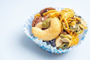 Cereal Cookies in a paper cup on a white background, Pumpkin, oat cookies with cranberries, cashew nut, sesame. soft focus.