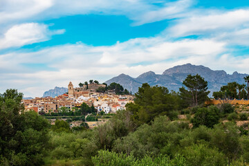 Fototapeta na wymiar The ancient Spanish city of Polop in the province of Alicante, Costa Blanca against the backdrop of beautiful landscapes, mountains and blue sky with clouds. Travel and family vacation concept.