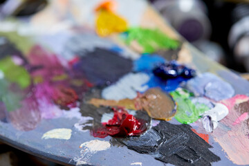 Tubes of oil paint, palette and artist paintbrushes closeup