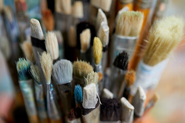 Tubes of oil paint, palette and artist paintbrushes closeup
