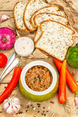 Vegan stew with a set of fresh vegetables. Chopped cooked ingredients, bread, cutlery, and spices