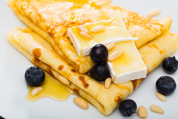 Warm crepes with brie cheese, honey, pine nuts, berries, served with honey