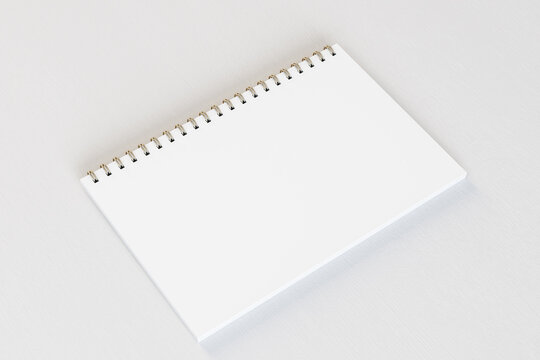 Close up of empty white spiral notepad on light desktop background. Mock up, 3D Rendering.