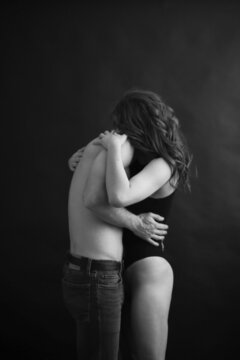 Sensual touches between a man and a woman, a beautiful fashion portrait of a couple, body details with a slight element of eroticism. A place for text and a blurred fleur of love