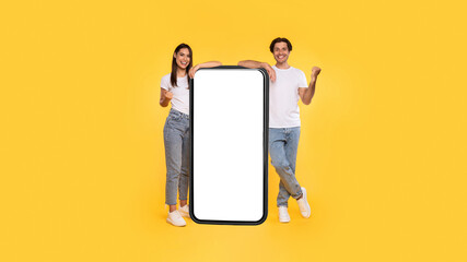 Couple showing white empty smartphone screen and gesturing yes