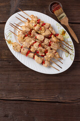 Kebabs - grilled meat skewers, skewers with vegetables on a brown wooden background. Grilled meat skewers. Top view, copy space.