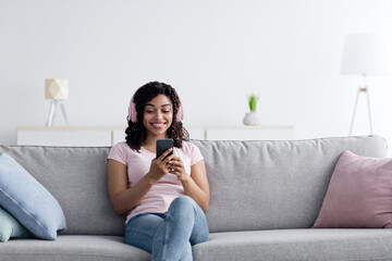 Obraz premium Lady listening music and chatting on phone, enjoy relax on couch at home