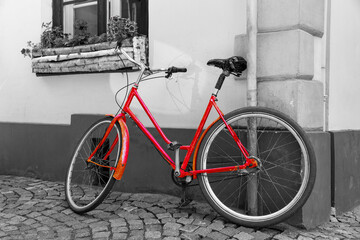 Fototapeta na wymiar Red bicycle on cobblestone street in the old town, Black And White