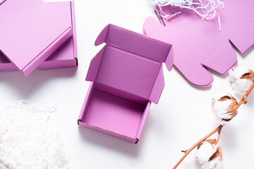 Pink cardboard carton box, top view, on wooden desk