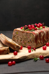 Traditional French terrine covered with bacon on dark wooden background