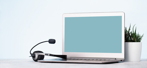 business and communications. Front view of mockup laptop monitor with headset. Conference call,...