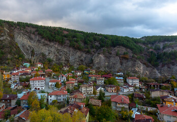 Historical old white small wooden houses of Mudurnu among mountains and trees.