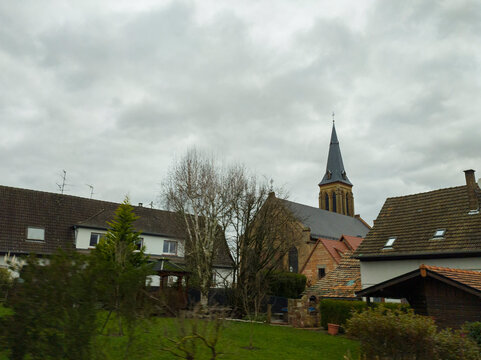 Fototapeta view from the car window on the street with houses in France in the city of Betschdorf