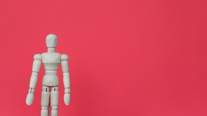 Close up image of wooden doll on red background with copy space.