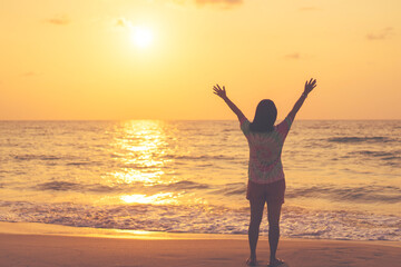 Fototapeta premium Copy space of woman rise hand up on sunset sky at beach and island background.