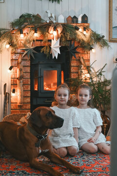 girls with a dog by the fireplace