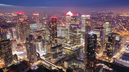 Fototapeta na wymiar Aerial drone night shot of iconic illuminated with Christmas lights skyscraper banking and business complex of Canary Wharf, Docklands, London, United Kingdom