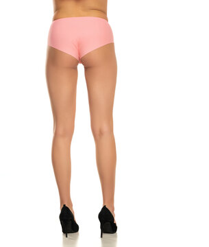 Rear view of pretty female legs in pink panties and high heels