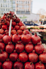 ripe pomegranates on the counters of the farmers' market. the seasonal fruits are organically grown. street vegetable fruit market. seasonal vitamins for health
