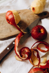 peeling apples. red apples and peel of red apples. beautifully twisted apple peel. cooking apple pie.