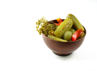 A mixture of pickled vegetables in a ceramic cup on a white background.