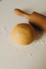 dough preparation. preparation of shortcrust pastry in the home kitchen. a ball of shortcrust pastry with a rolling pin on the table top. blanks for the pie.
