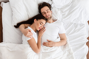 Married Couple Sleeping Embracing In Comfortable Bed Indoor, Top View