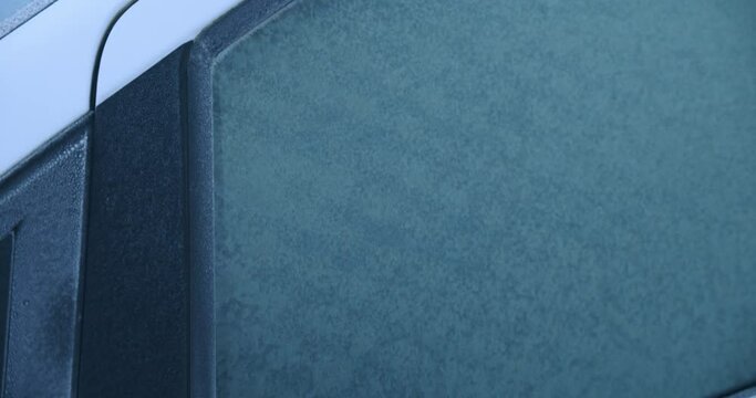 A car covered by frost on a winter morning, close up, slow motion