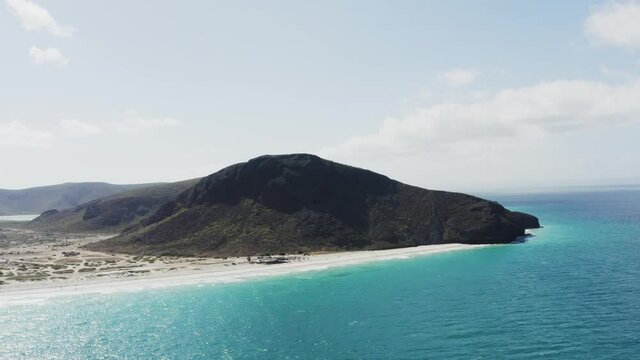 A drone rises over blue water of Tecolote Beach, Baja Mexico