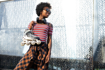 Fototapeta na wymiar Beautiful African woman with roller skates. Urban sexy girl enjoy outdoors