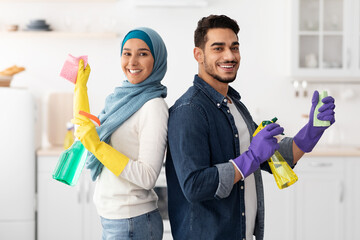 Cheerful middle-eastern husband and wife cleaning kitchen