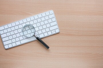 A magnifying glass on the computer keyboard