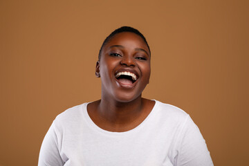 Portrait of casual young chubby black woman laughing