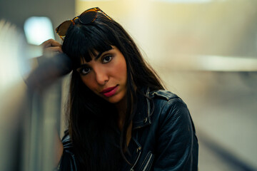 Fototapeta premium Portrait of Fashionable Hispanic woman in stylish clothing walking down cross street tunnel in the city at night. Confidence female in leather jacket enjoy urban outdoor lifestyle nightlife in summer