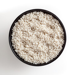 Uncooked arborio rice in BLACK bowl isolated on white background with clipping path