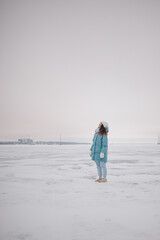 a beautiful girl walks on a frozen lake