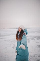 a beautiful girl walks on a frozen lake