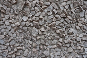 Gray gravel pebble dash on the wall (front view)
