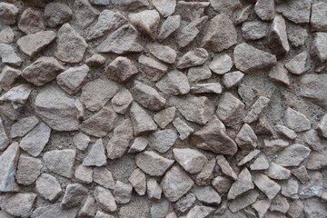 Surface of light gray gravel pebble dash on the wall