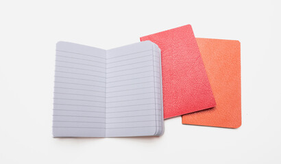 Notepad isolated on white background. Open copybook, blank page on red and orange color notebook,