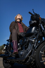 Mature woman with a leather jacket in a black motorbike feeling the wind in her skin
