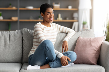 Obraz premium Domestic Comfort. Portrait Of Smiling Young Black Female Resting In Home Interior