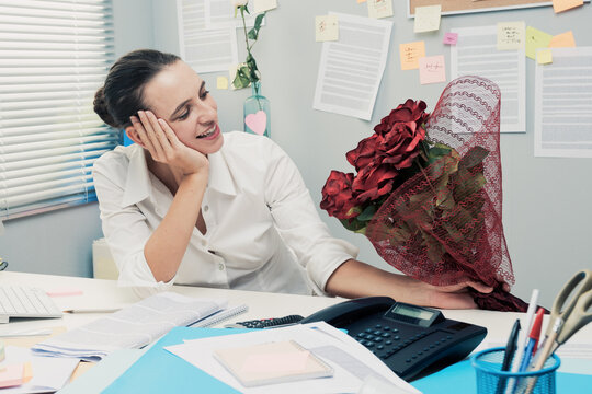 Woman receiving a romantic surprise at work.